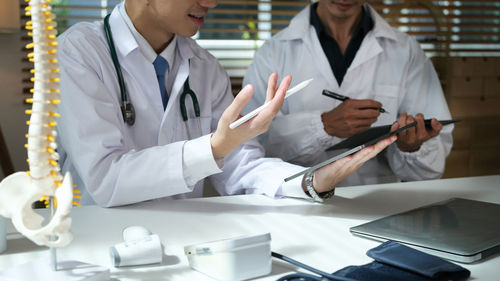 Midsection of doctor examining patient in laboratory