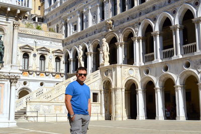 Portrait of a smiling man standing in front of building