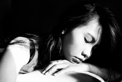 Close-up of young woman napping on table