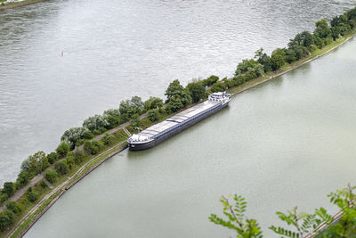 Barge with a covered deck attached to the river bank, aerial view.