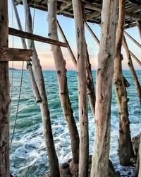 Wooden posts on beach against sky