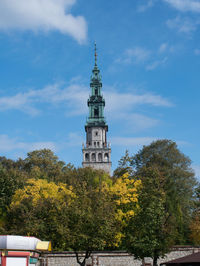 Low angle view of trees and building against sky