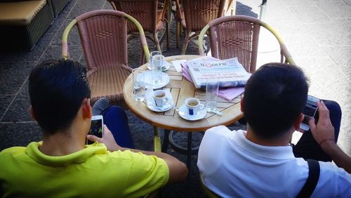 High angle view of people sitting on table