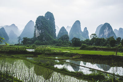 Scenic view of river by mountains against sky