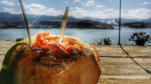 Close-up of food in sea against sky