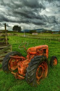 Scenic view of grassy field against cloudy sky