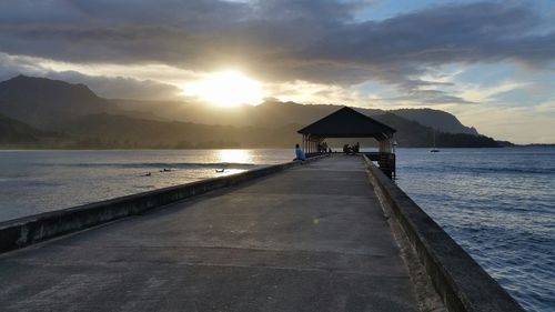 Pier on sea at sunset