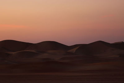 Scenic view of desert against sky during sunset