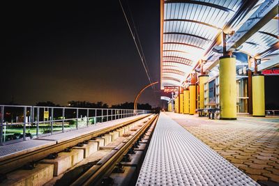 Train at railroad station against sky at night