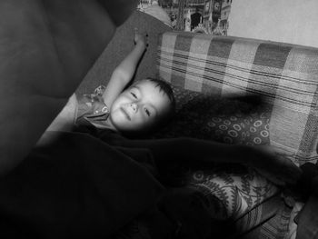 Portrait of boy lying on sofa at home