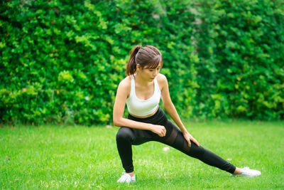 Full length of young woman sitting on grass