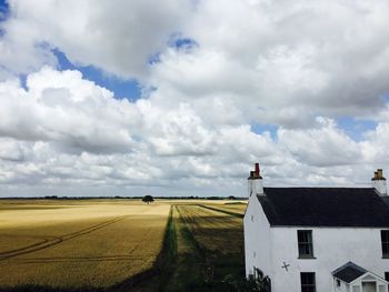 Rural landscape against cloudy sky