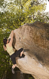 Mature woman bouldering in the forest of fontainebleau close to paris