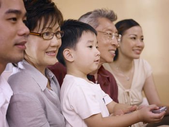 Multi-generation family watching tv while sitting at home