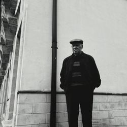 Man standing against brick wall