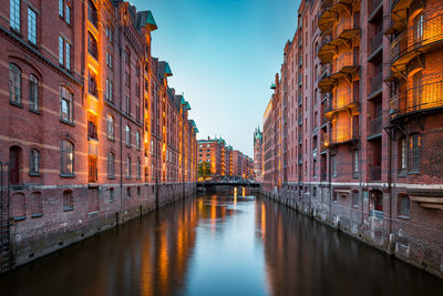 Bridge over canal amidst buildings in city