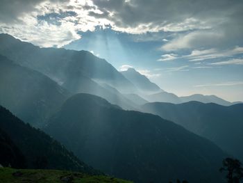 Scenic view of mountains against cloudy sky