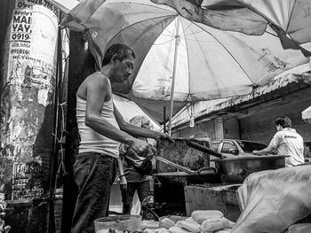 Side view of man preparing food at market