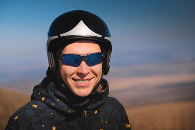 Portrait of young woman wearing sunglasses against sky during sunset