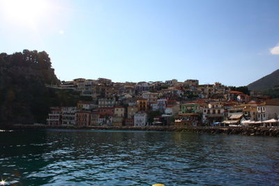 Buildings by river against sky in town