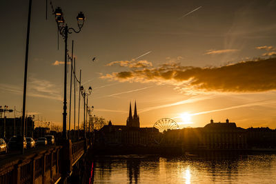 Bridge over river against sky during sunset