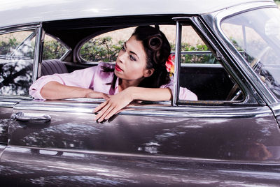 Young woman in vintage car