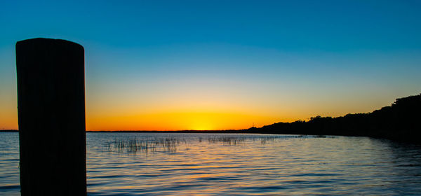 Scenic view of sea against clear sky at sunset