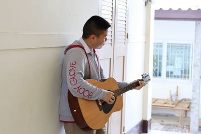 Full length of boy playing guitar