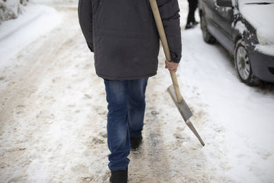 Snow removal. man with shovel for snow removal. work in yard in winter.