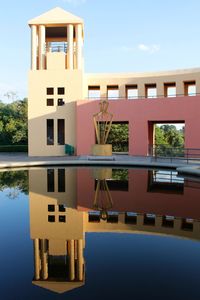 Reflection of building in lake against sky