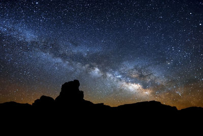 Silhouette mountain against sky at night