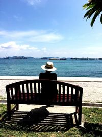 Bench sitting on table by sea against sky