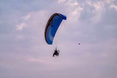 Low angle view of person paragliding against sky