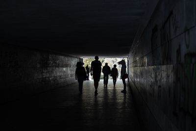 Silhouette people walking in tunnel
