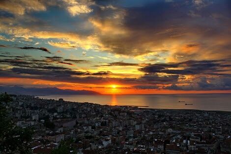 sunset, sky, sea, orange color, building exterior, architecture, cloud - sky, built structure, cityscape, horizon over water, sun, water, scenics, city, beauty in nature, high angle view, cloud, dramatic sky, nature, cloudy