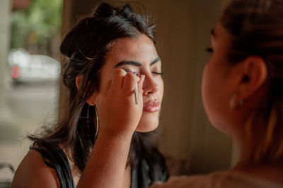 Make up artist working with a young woman