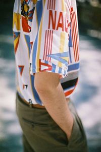 Midsection of man standing at beach against sky