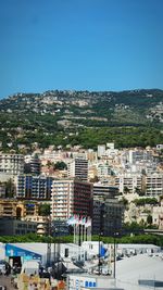 Buildings in city against clear blue sky