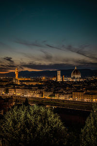 Illuminated cityscape against sky at night