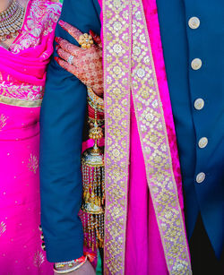 Midsection of woman standing with pink umbrella