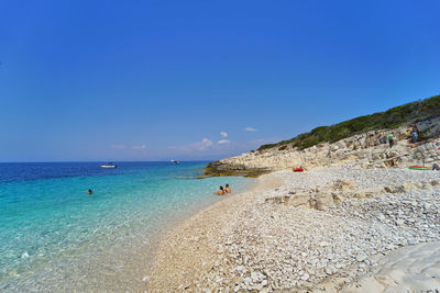 Scenic view of beach against clear blue sky