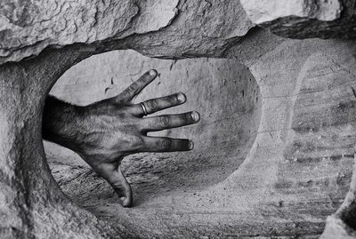 Cropped hand of man by rock formation