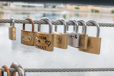 Close-up of padlocks on railing against bridge