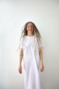 Portrait of a smiling young woman against white background