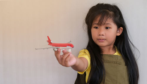 Portrait of happy girl holding toy airplane