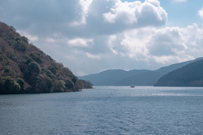 Scenic view of sea and mountains against sky