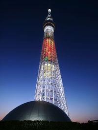 Low angle view of illuminated tower against sky at night