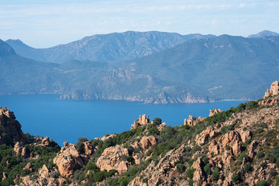 Scenic view of sea and mountains against sky