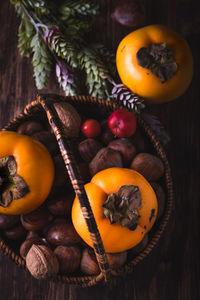 High angle view of fruits and nuts in wicker basket on table