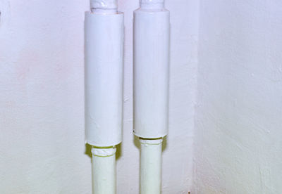 Close-up of pipes on table against white wall